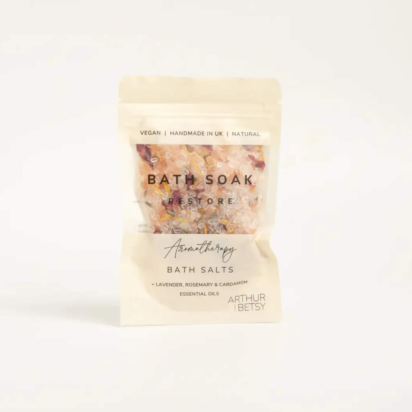 Arthur Betsy Restore Bath Salts in cream pouch with pink and yellow flower petals