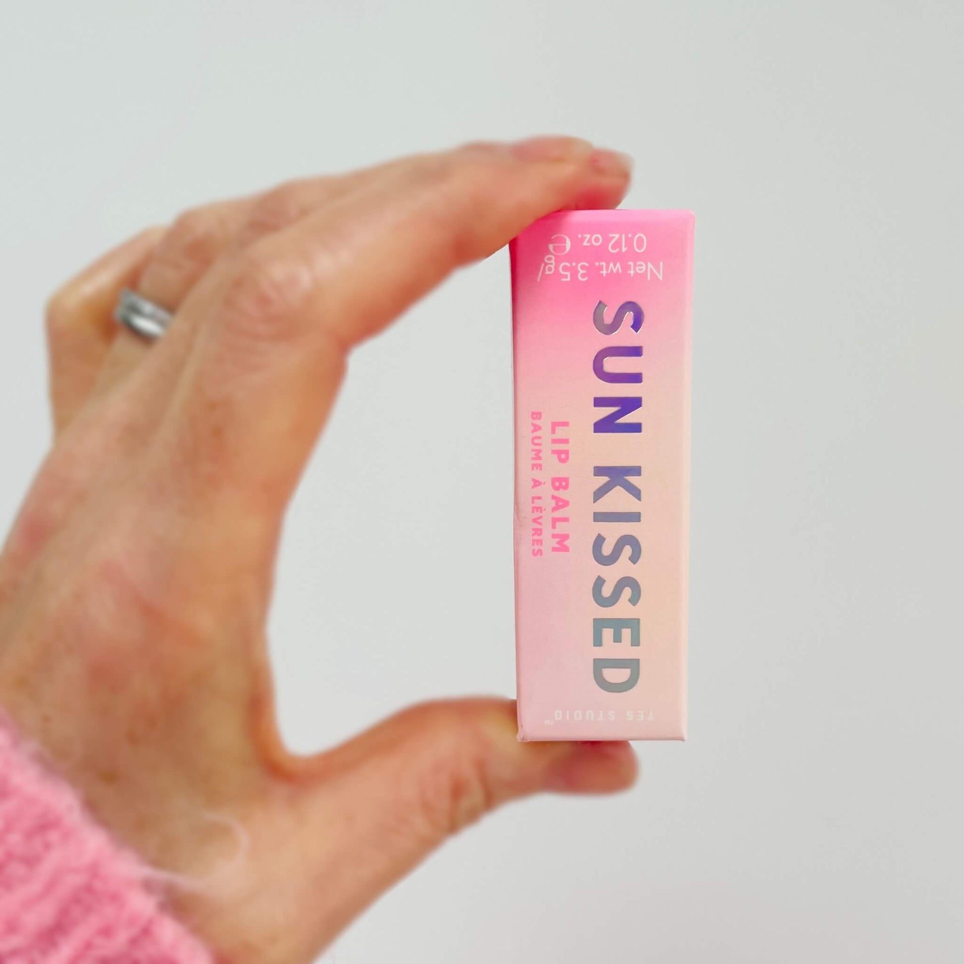 Hand holding cherry lip balm box