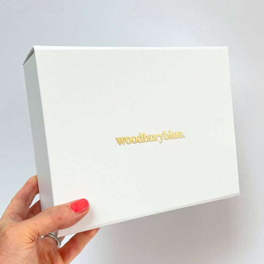 White luxury gift box with gold Woodbury Blue logo and ribbon pull tab