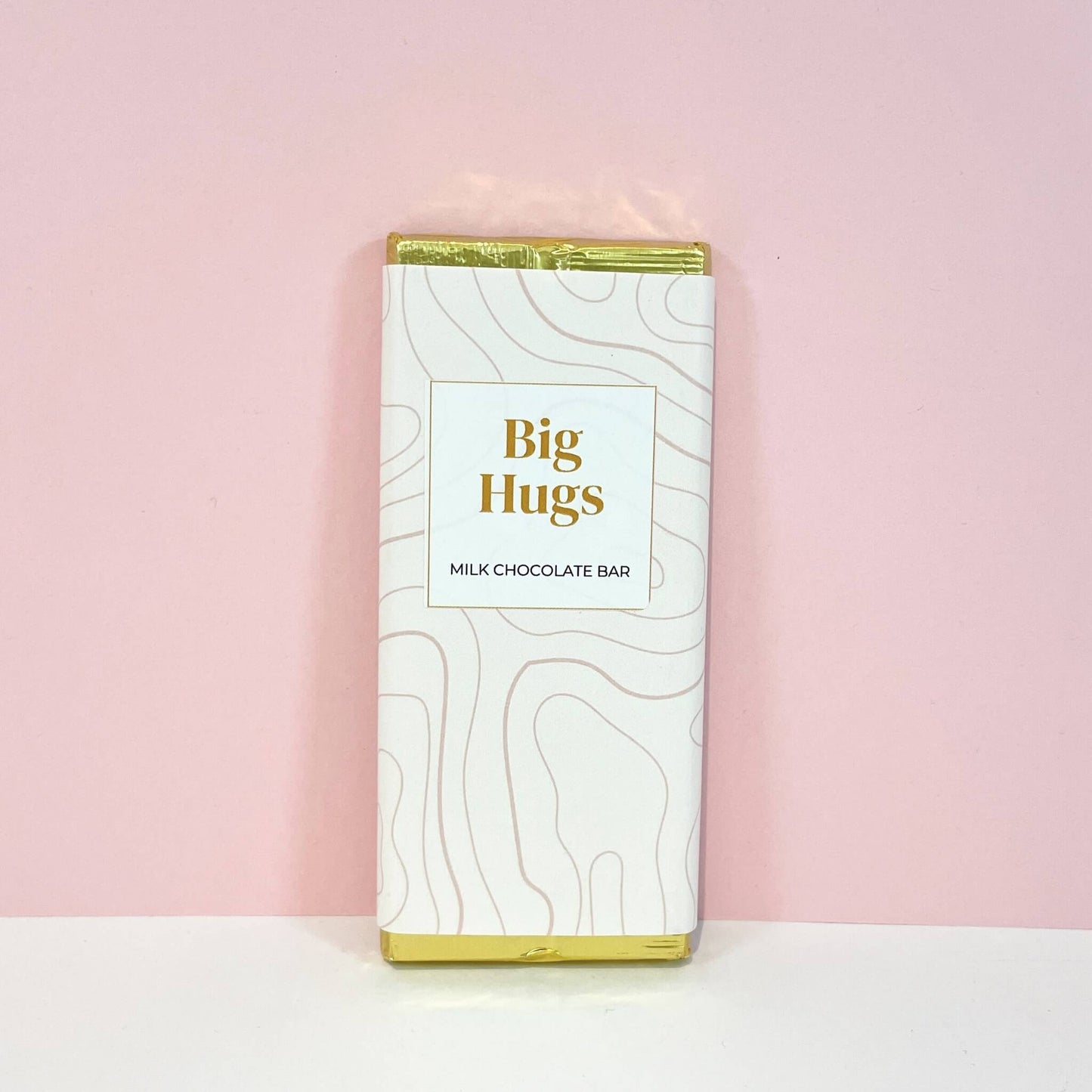 Milk chocolate bar with elegant white and gold packaging featuring the message "Big Hugs" – a sweet gift for comfort and cheer.