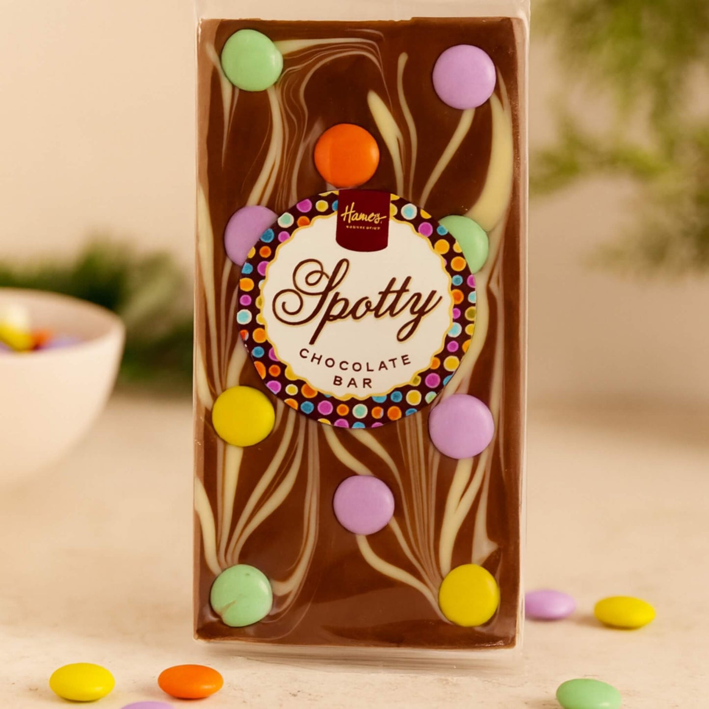 Spotty Chocolate Bar packaging with colorful buttons on a neutral background