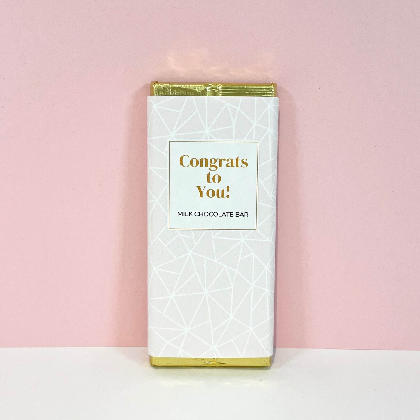 Milk chocolate bar with geometric white and blush design, displaying the message "Congrats to You!" – a celebratory chocolate gift.