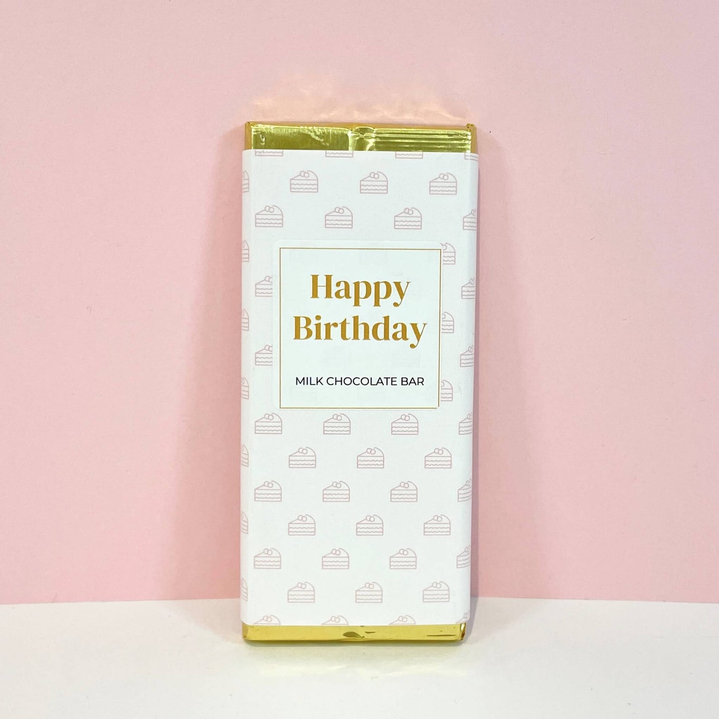Milk chocolate bar wrapped in cake-patterned packaging with the words "Happy Birthday" – a joyful birthday surprise.