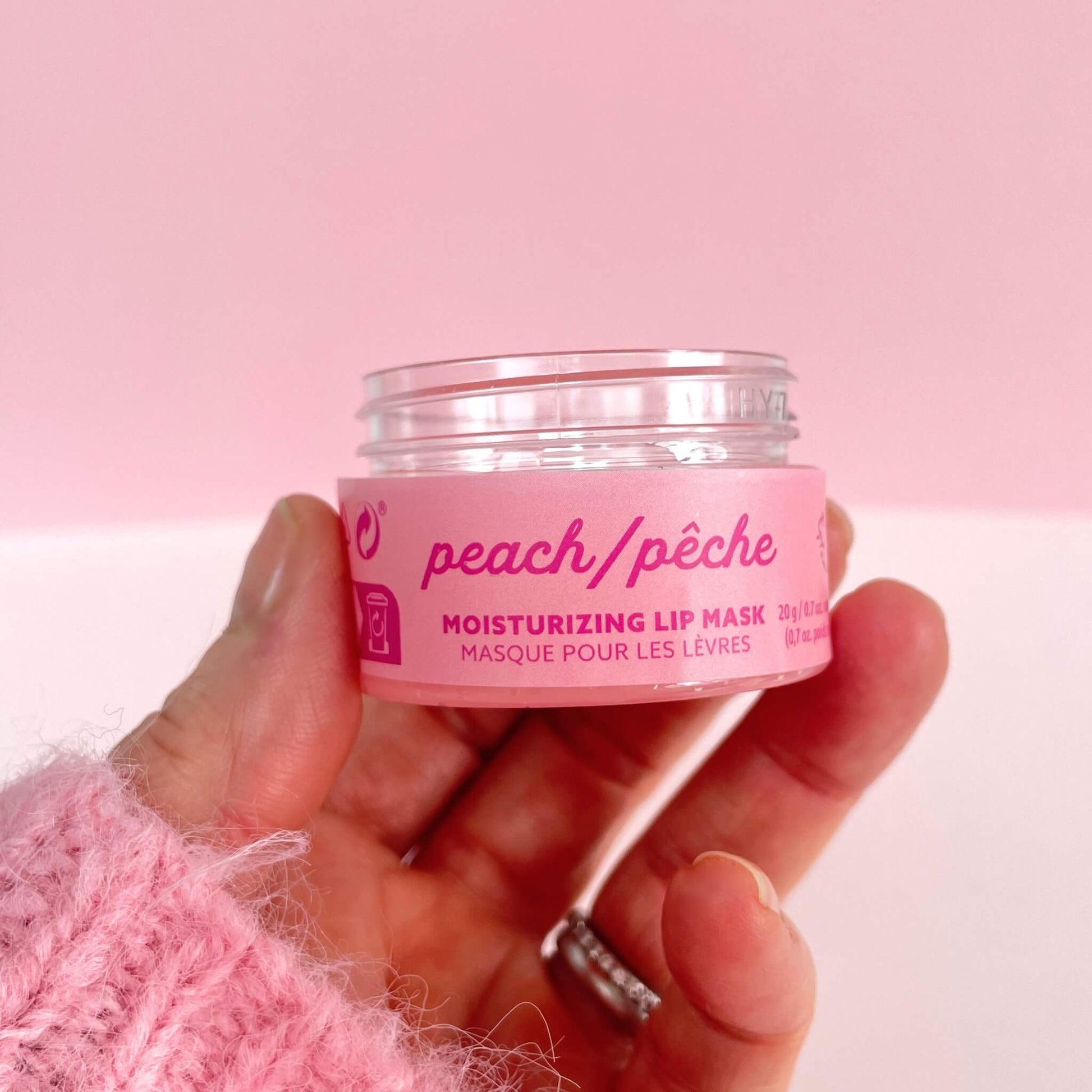 Hand holding moisturising peach lip mask