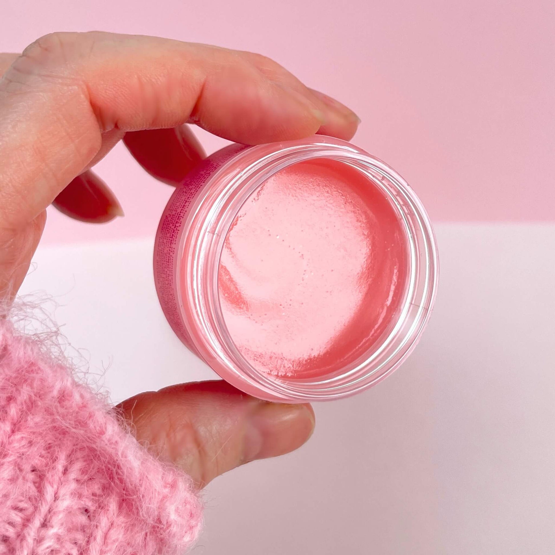 Open pot of shiny peach lip mask