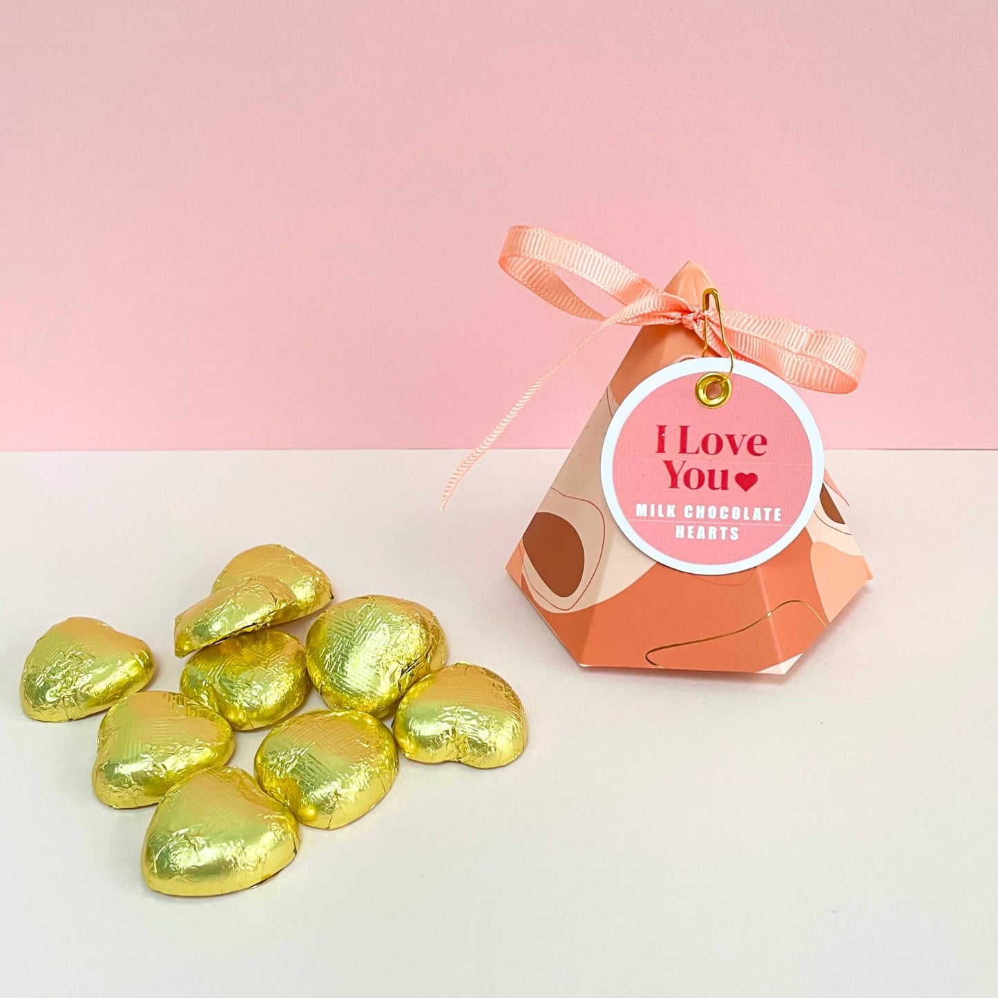 Gold foiled chocolate hearts displayed on pink background – sweet romantic gift