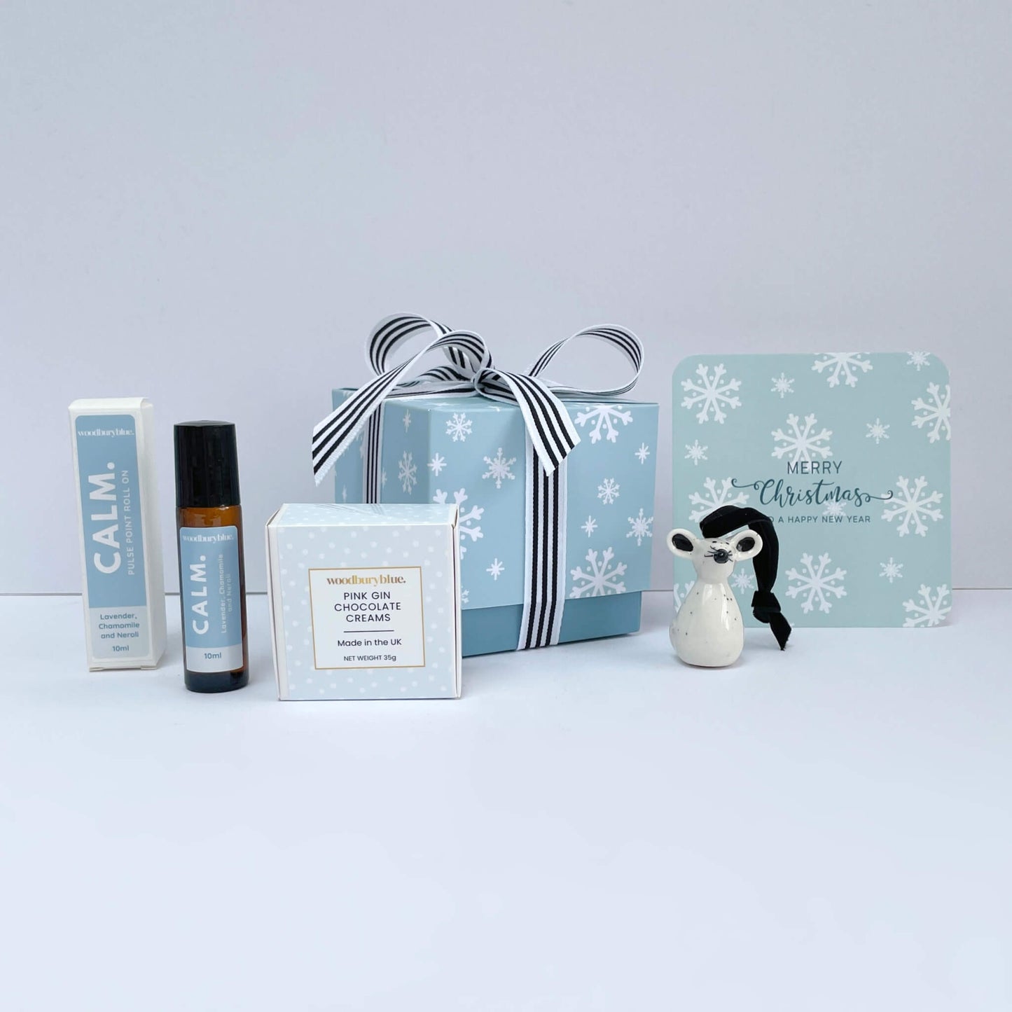 Full contents of Silent Night Christmas gift box – snowflake box with CALM roll-on, pink gin chocolates, and mouse ornament, with matching Christmas card.