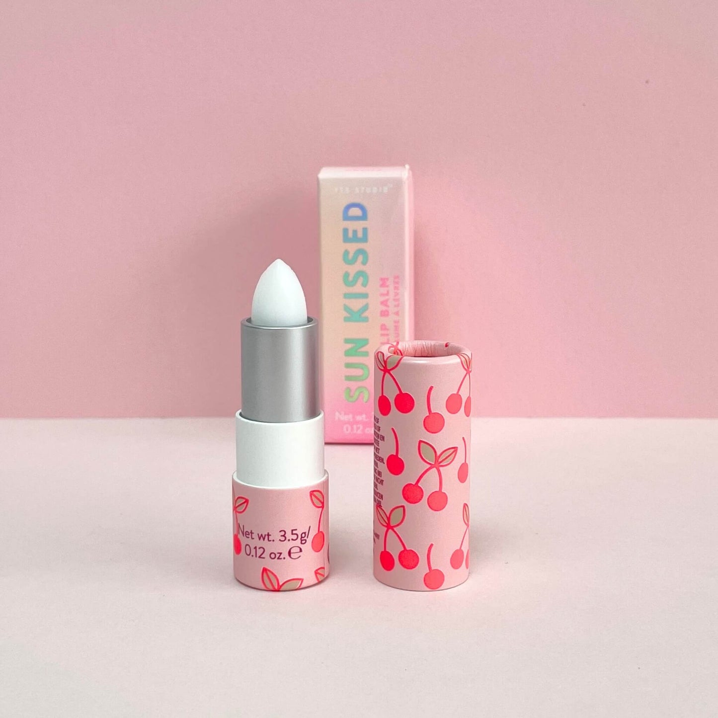 Cherry lip balm with the lid off and box in background