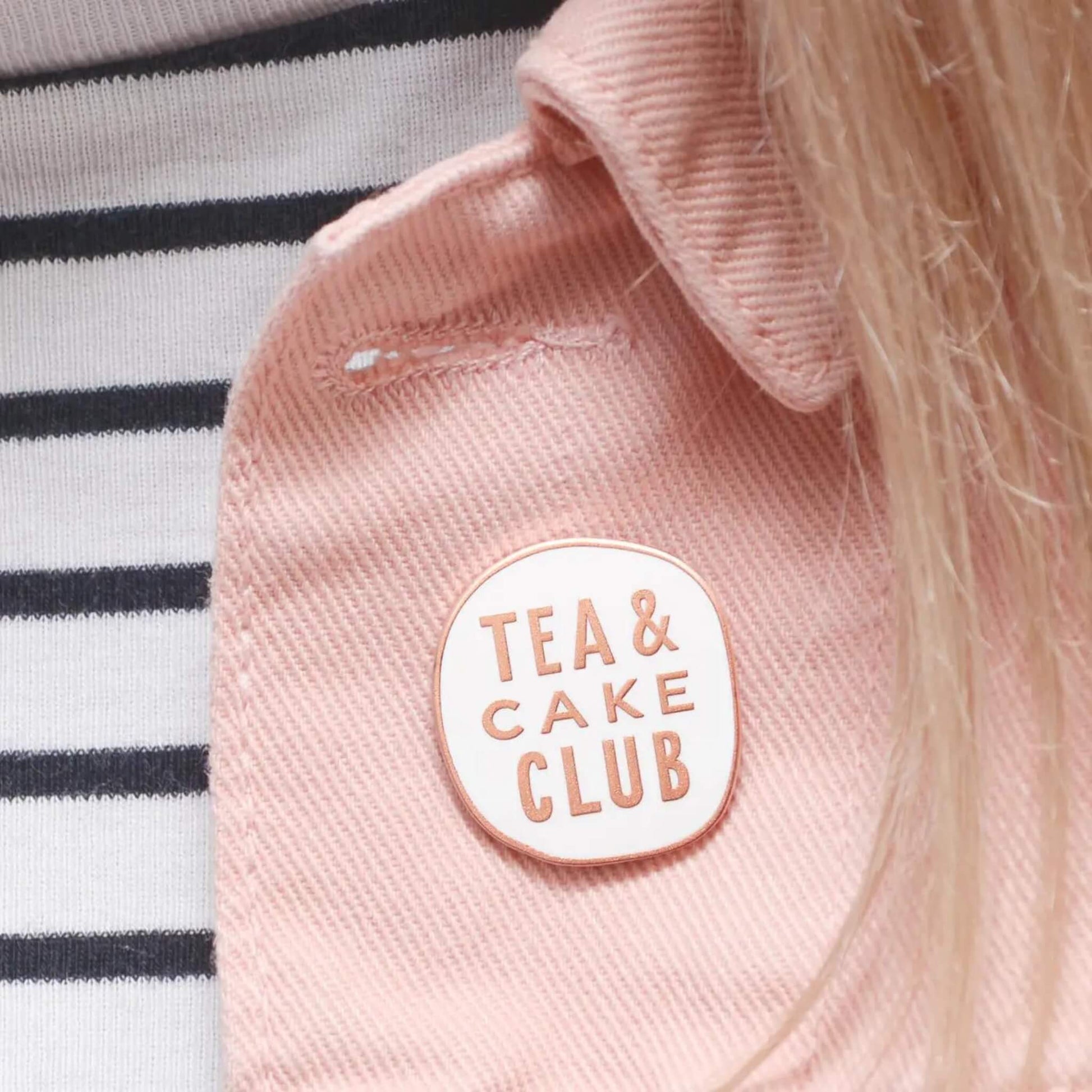 Tea and Cake Club enamel pin badge in white and gold on a pink cord jacket