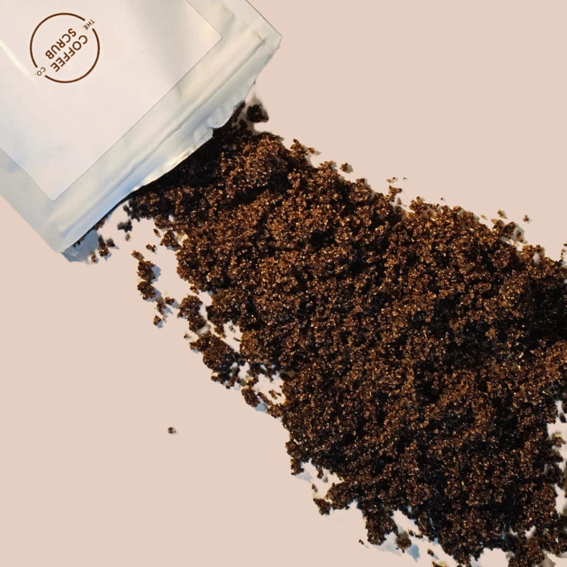anilla coffee body scrub spilling from pouch – natural exfoliant for soft, glowing skin