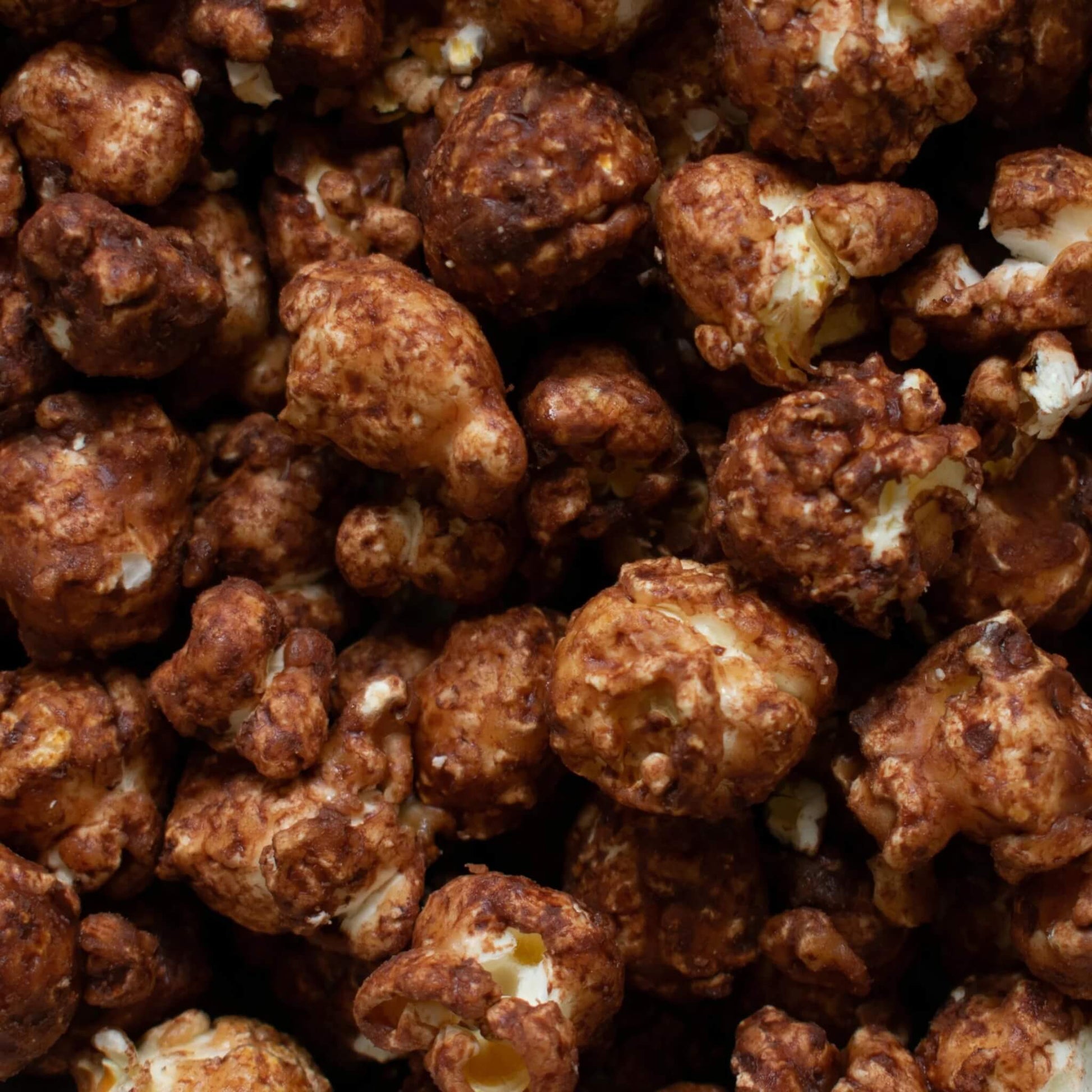 Close-up of Vegan Chocolate Orange Gourmet Popcorn showing dark chocolate coating and rich caramel texture.