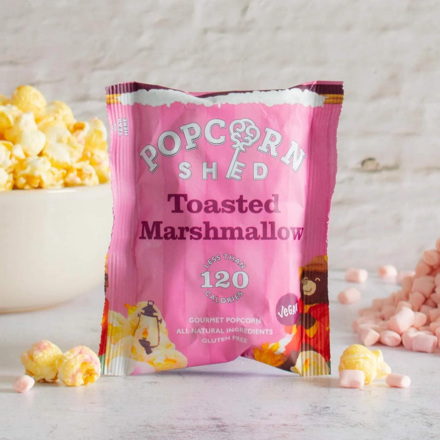 Pink 'Popcorn Shed' toasted marshmallow popcorn bag with popcorn and marshmallows on a light background