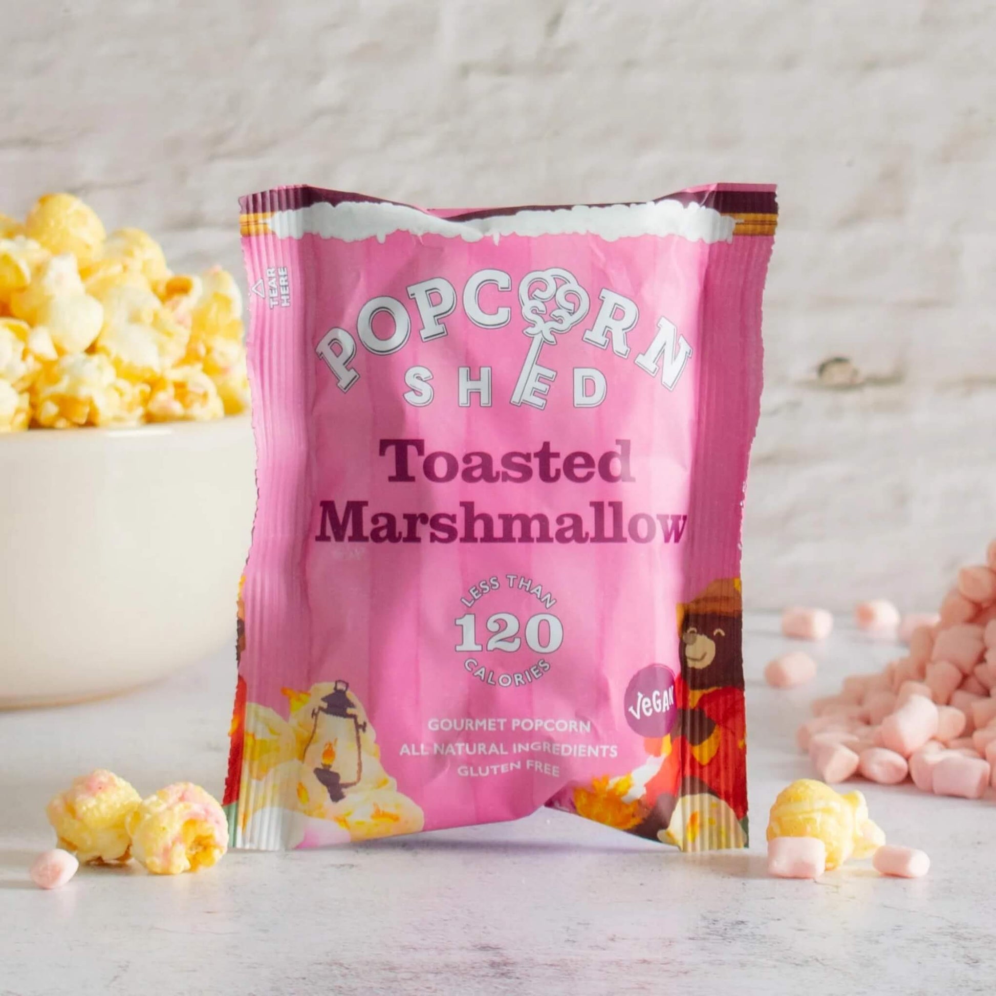 Pink 'Popcorn Shed' toasted marshmallow popcorn bag with popcorn and marshmallows on a light background