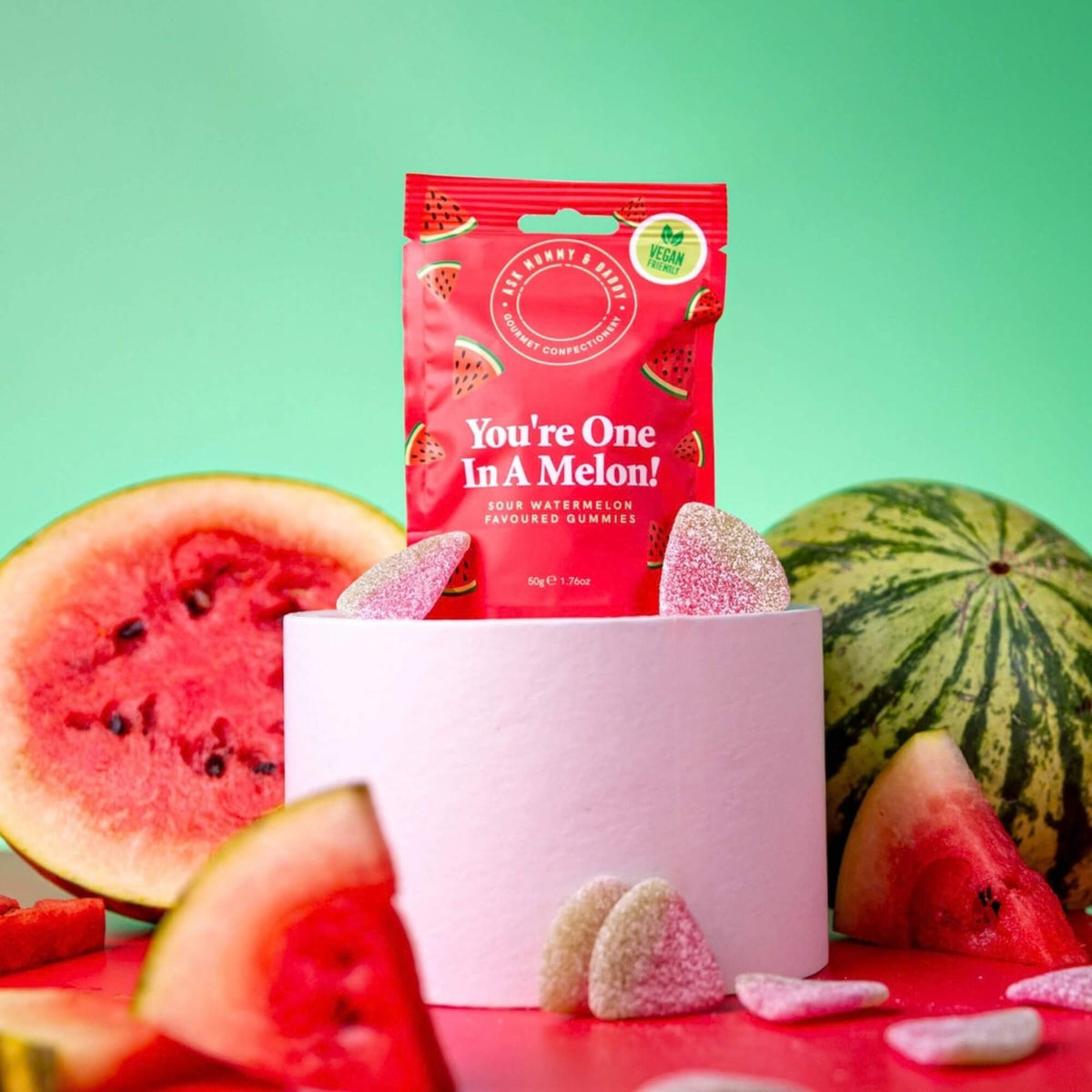 Ask Mummy & Daddy You’re One in a Melon gummy sweets displayed with watermelon slices