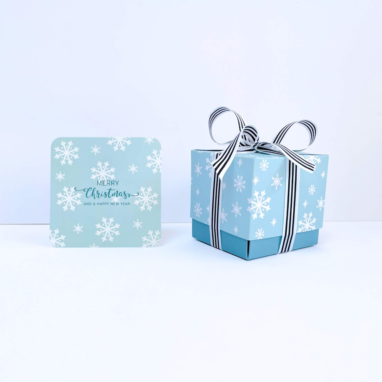 Blue gift box with snowflake design and matching Merry Christmas notecard