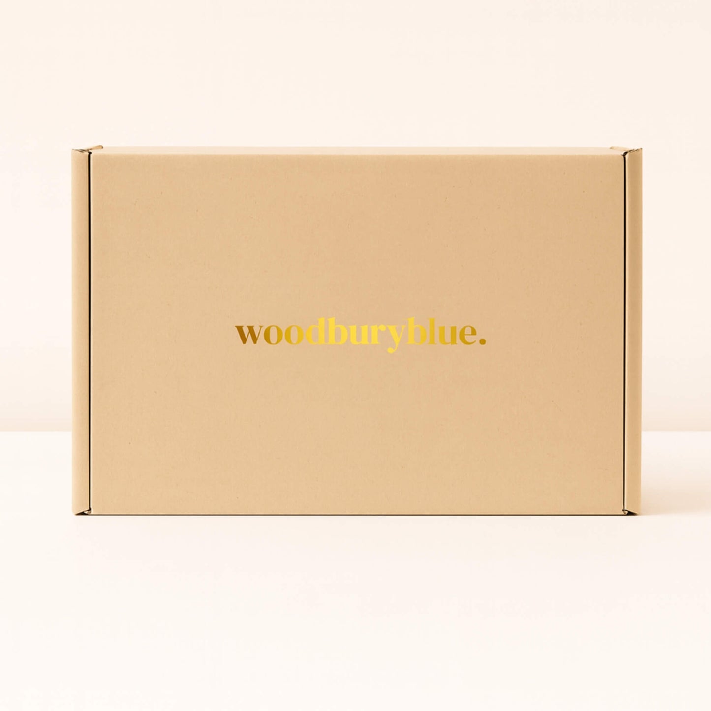 Kraft gift box with simple matt gold Woodbury Blue logo on the front