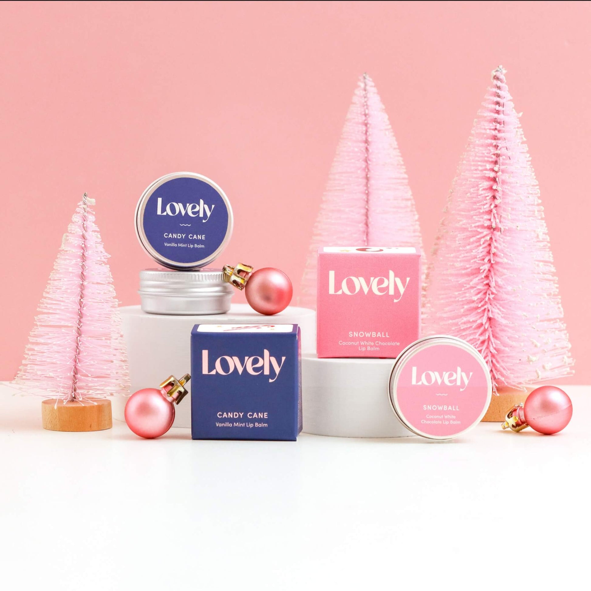 Lovely Skincare Candy Cane and Snowball Lip Balms with pink bottle brush Christmas trees