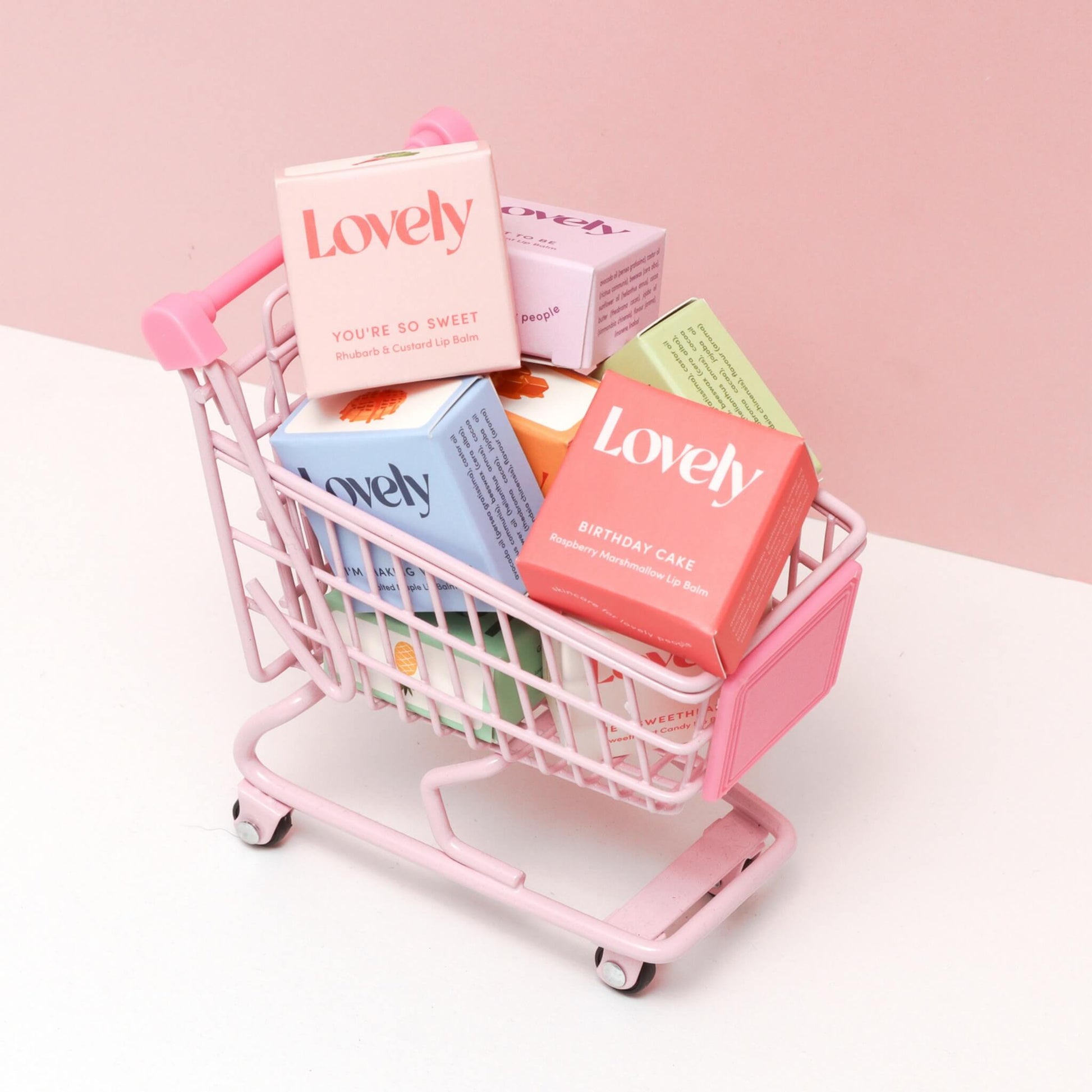 Lovely Skincare Birthday Cake Lip Balm with assorted lip balm boxes in pink miniature shopping trolley
