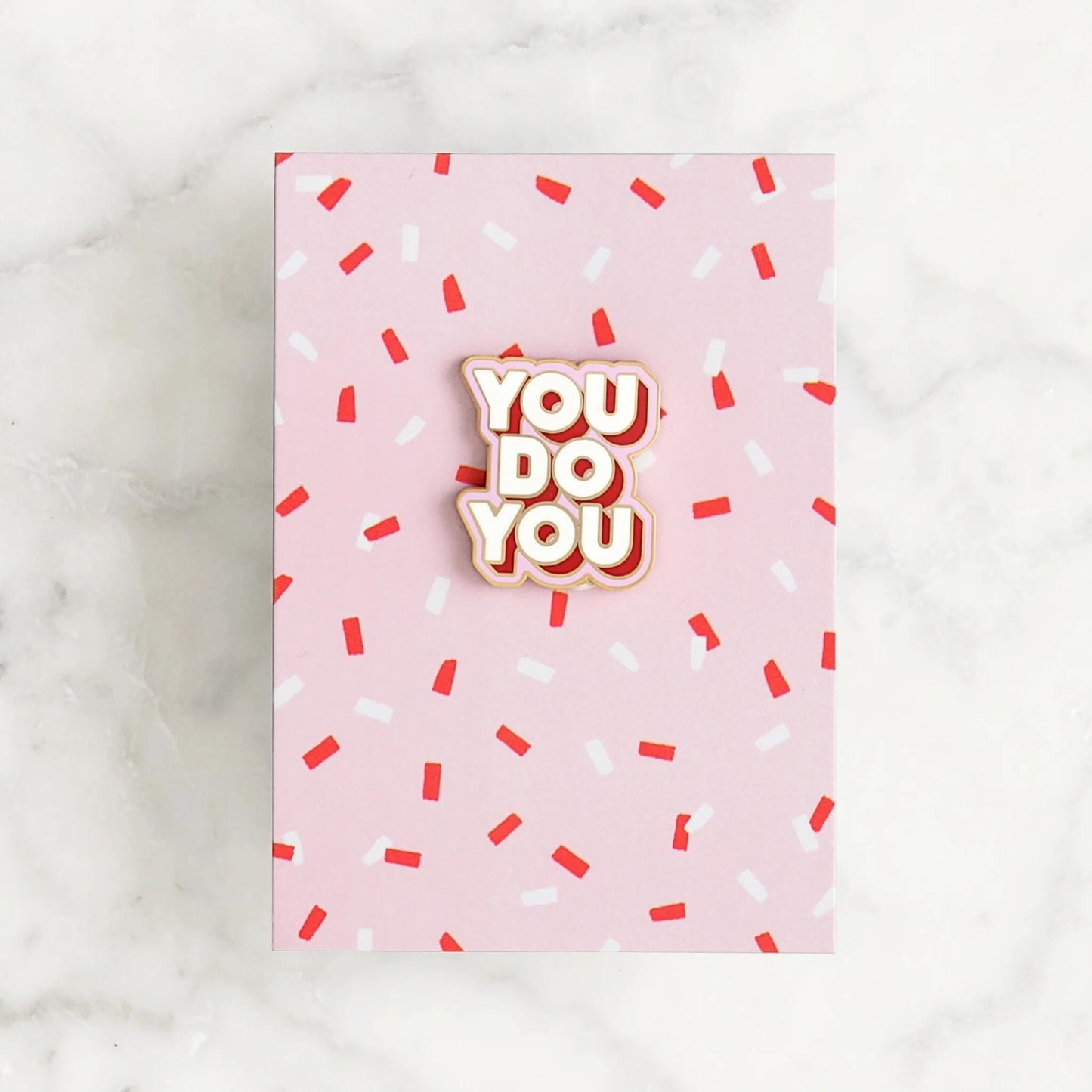 You Do You enamel pin badge with gold edge on pink card with red and white sprinkles