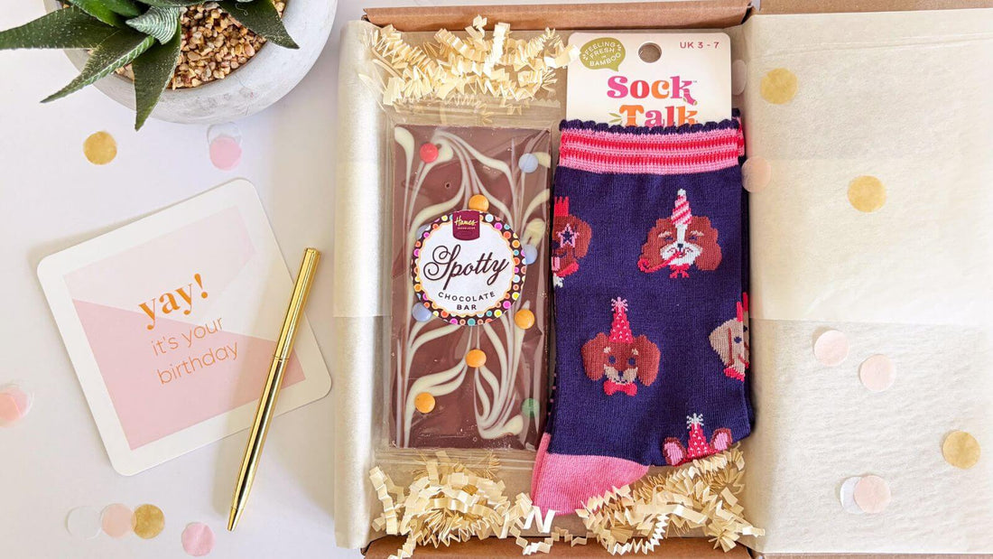 Birthday gift box with patterned socks, chocolate bar and birthday card