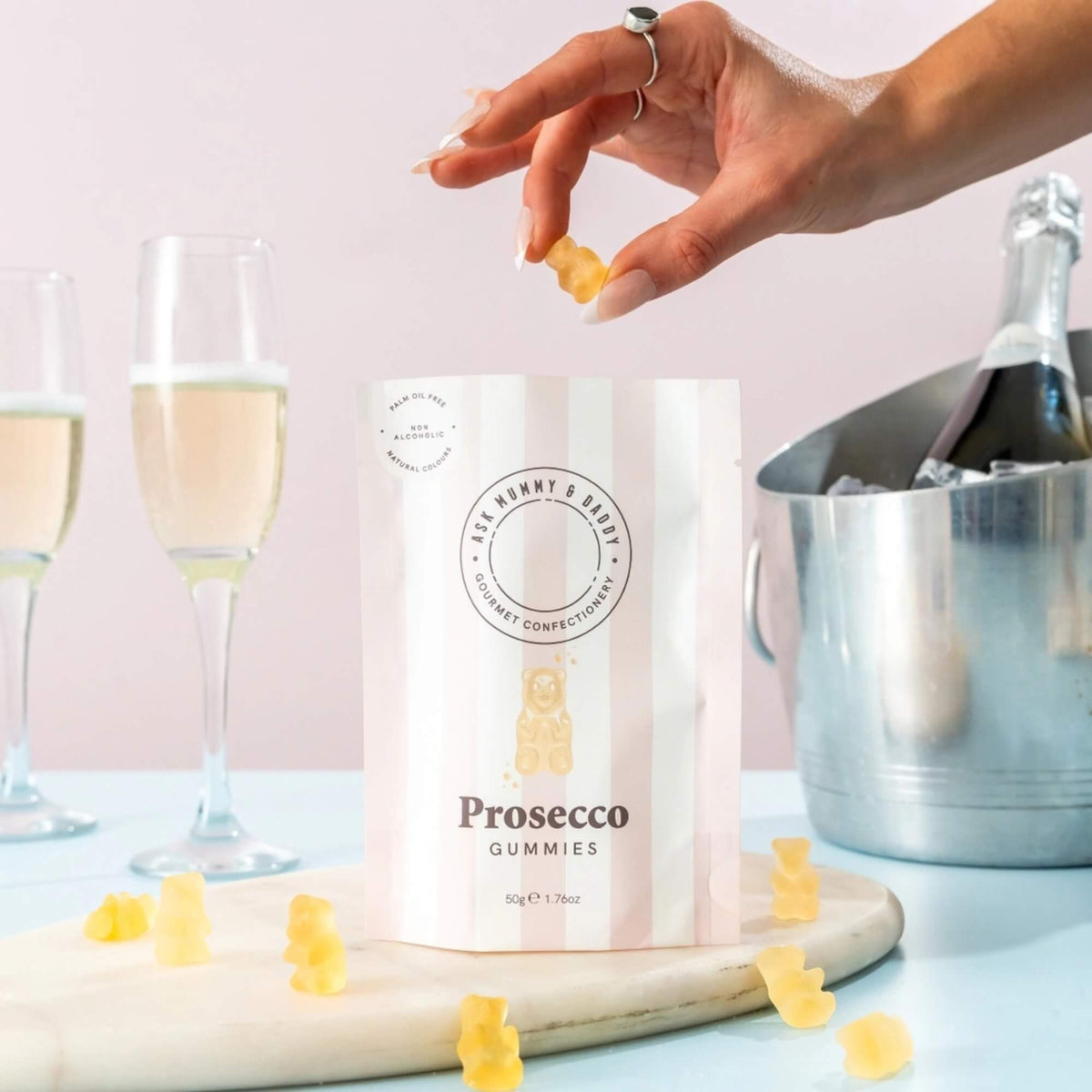 Ask Mummy & Daddy Prosecco Gummies displayed with glasses of sparkling drink and gummy bears