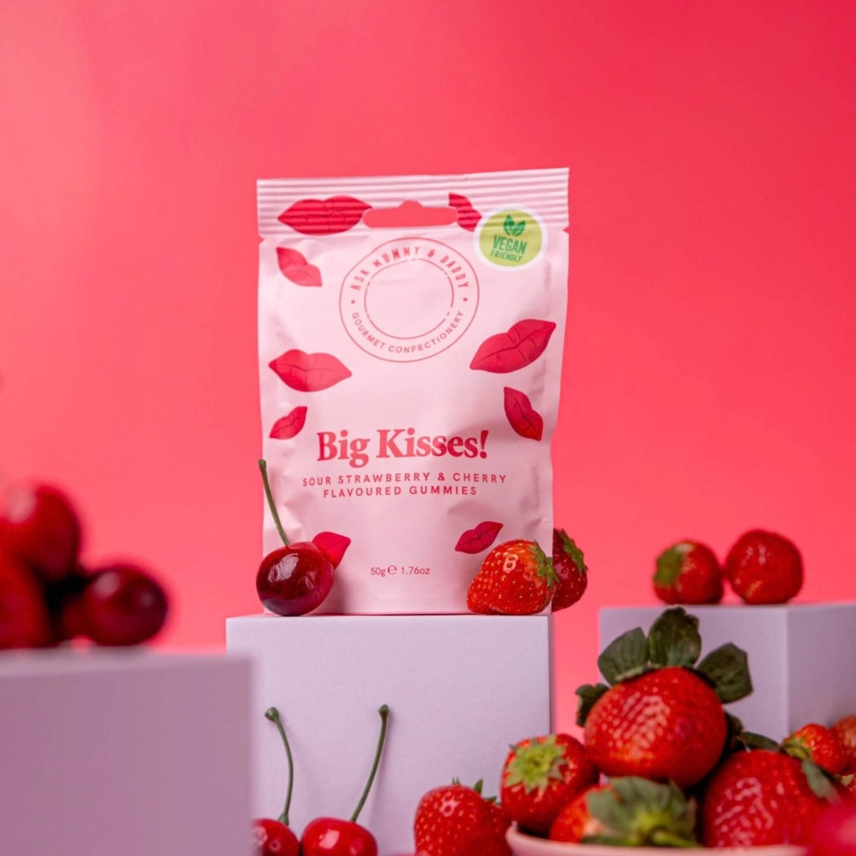 Big Kisses vegan sour gummy sweets styled with fresh strawberries and cherries