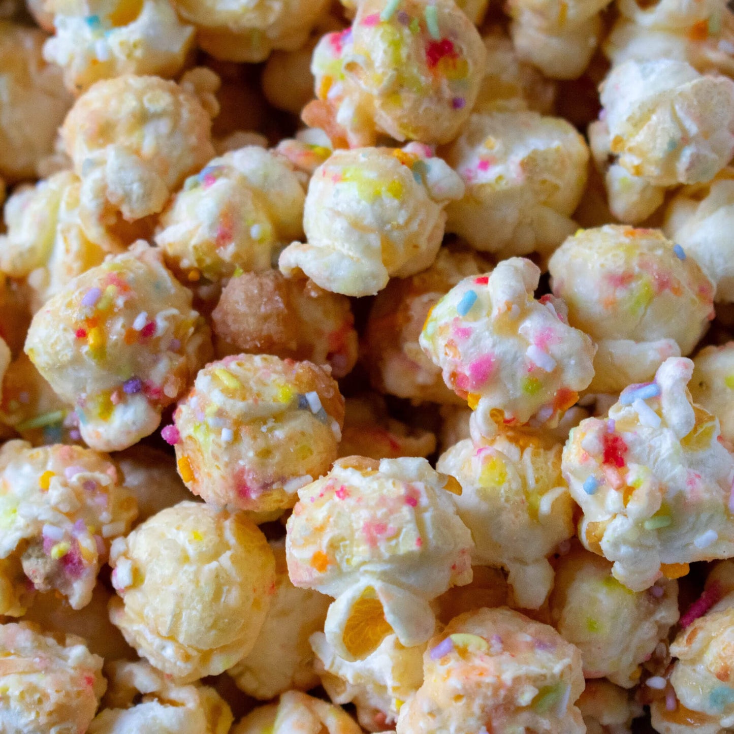 Close-up of Birthday Cake Gourmet Popcorn coated in caramel with colourful birthday cake sprinkles.