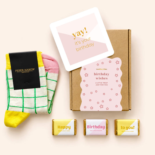 Birthday Treats Socks and Chocolate Letterbox Gift featuring cream and green checked Peper Harow socks, three birthday milk chocolates, a pink birthday notecard and a kraft gift box.