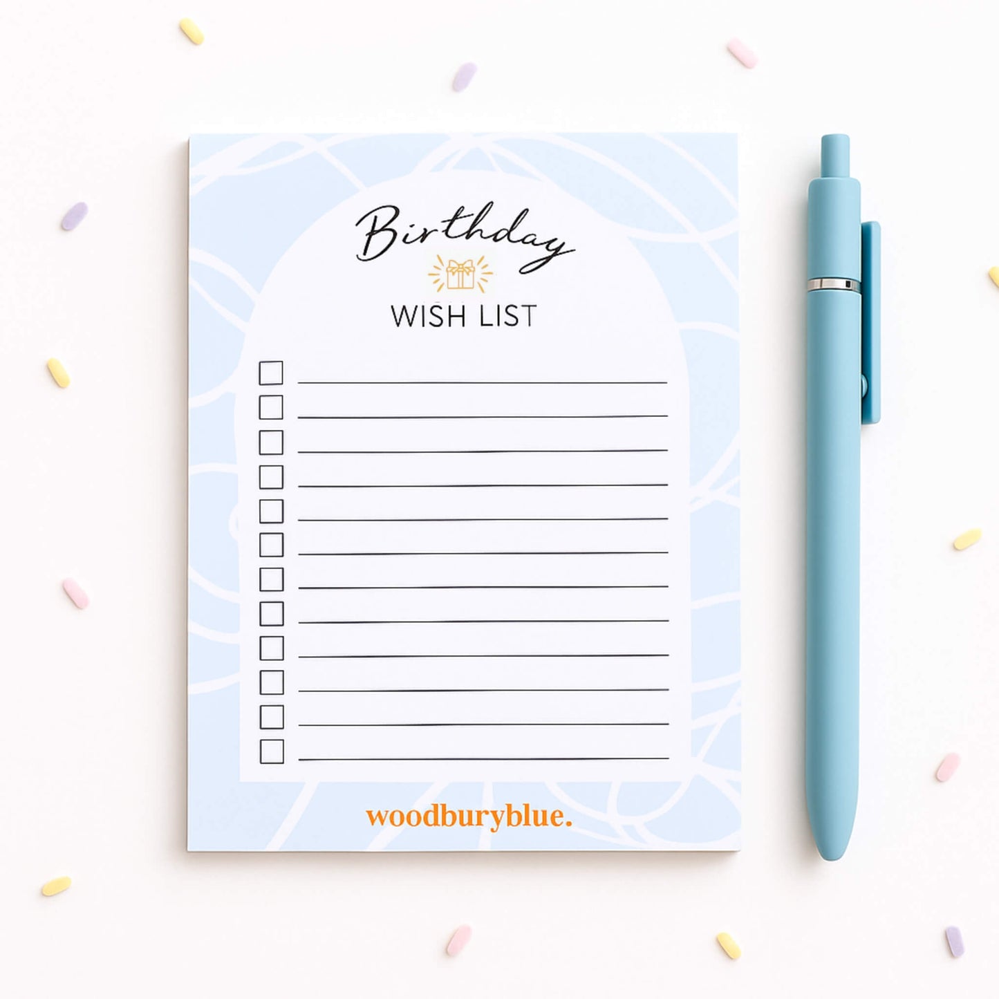 Birthday Wish List notepad in soft blue with pastel confetti background and blue pen, designed by Woodbury Blue with 50 tear-off lined pages and premium 100gsm paper.