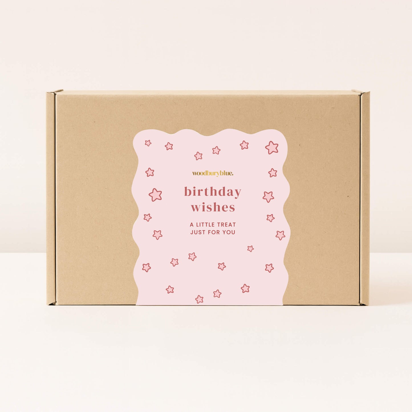 Kraft gift box with pink birthday wishes sticker covered in star pattern from Woodbury Blue