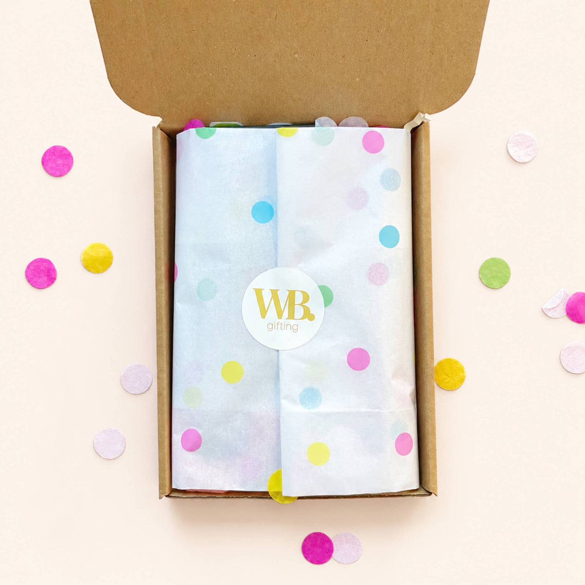 Open Woodbury Blue birthday letterbox gift box with contents wrapped in pastel polka dot tissue paper and sealed with a WB gifting sticker.