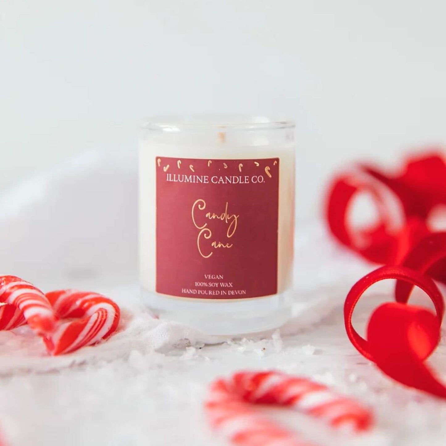 Candy cane scented soy wax candle in a glass jar with a red label