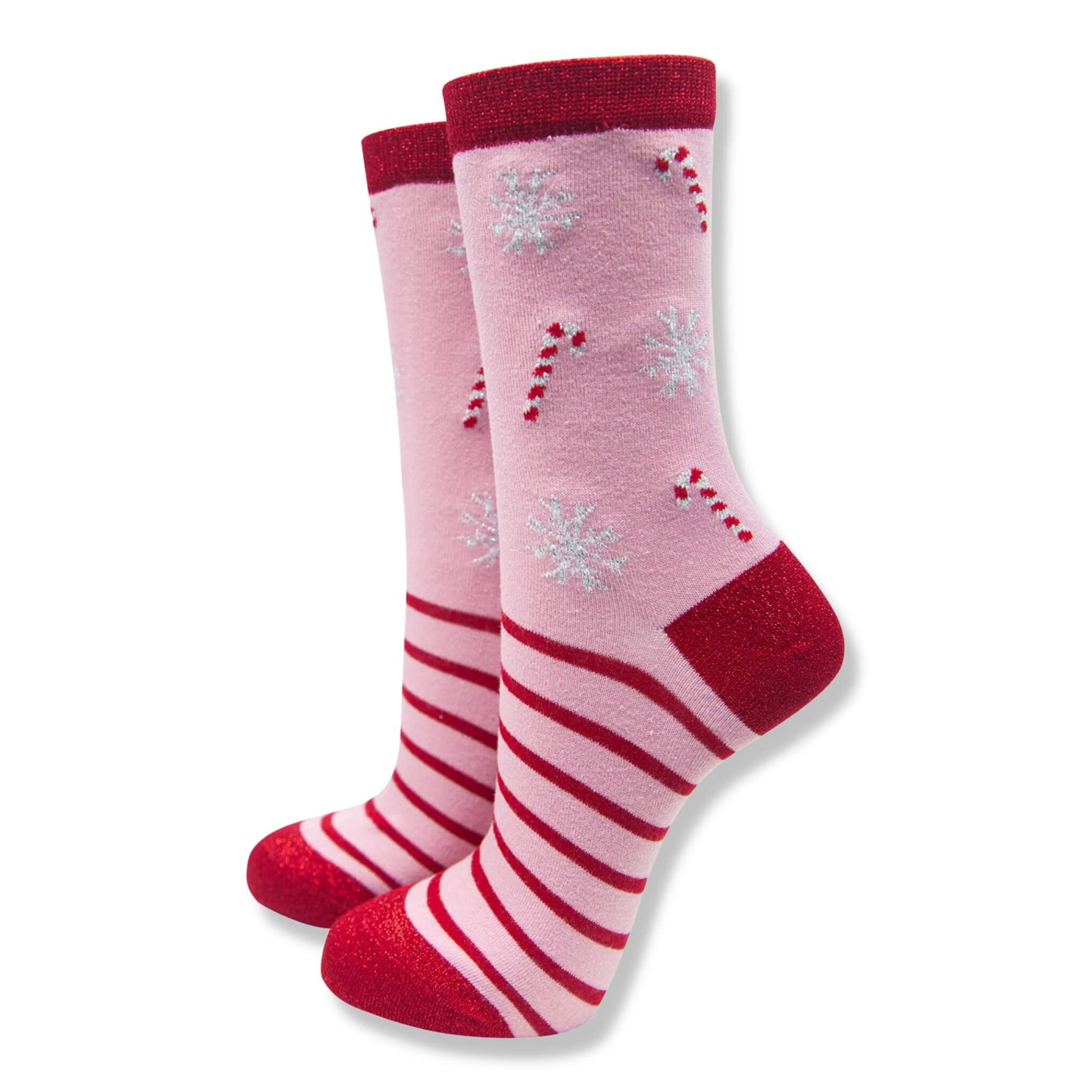 Pink and red Christmas socks with a candy cane pattern and white glitter snowflakes