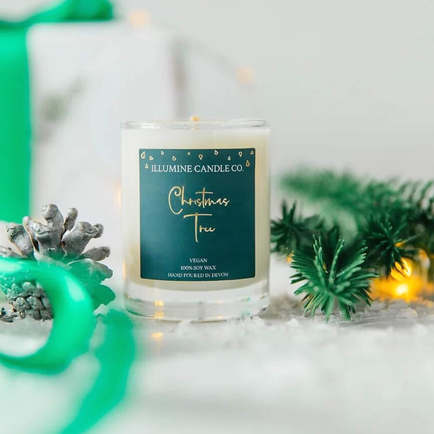 Christmas tree scented candle in a glass jar with a green and gold label