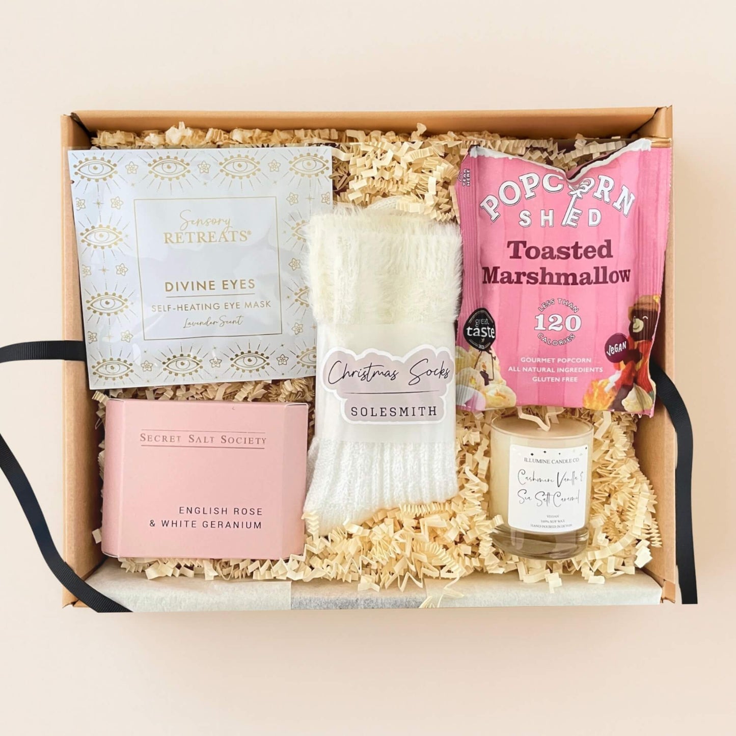 p down view of the Cosy Christmas Gift Box showing fluffy socks, Sensory Retreats eye mask, popcorn, bath soak and winter candle.