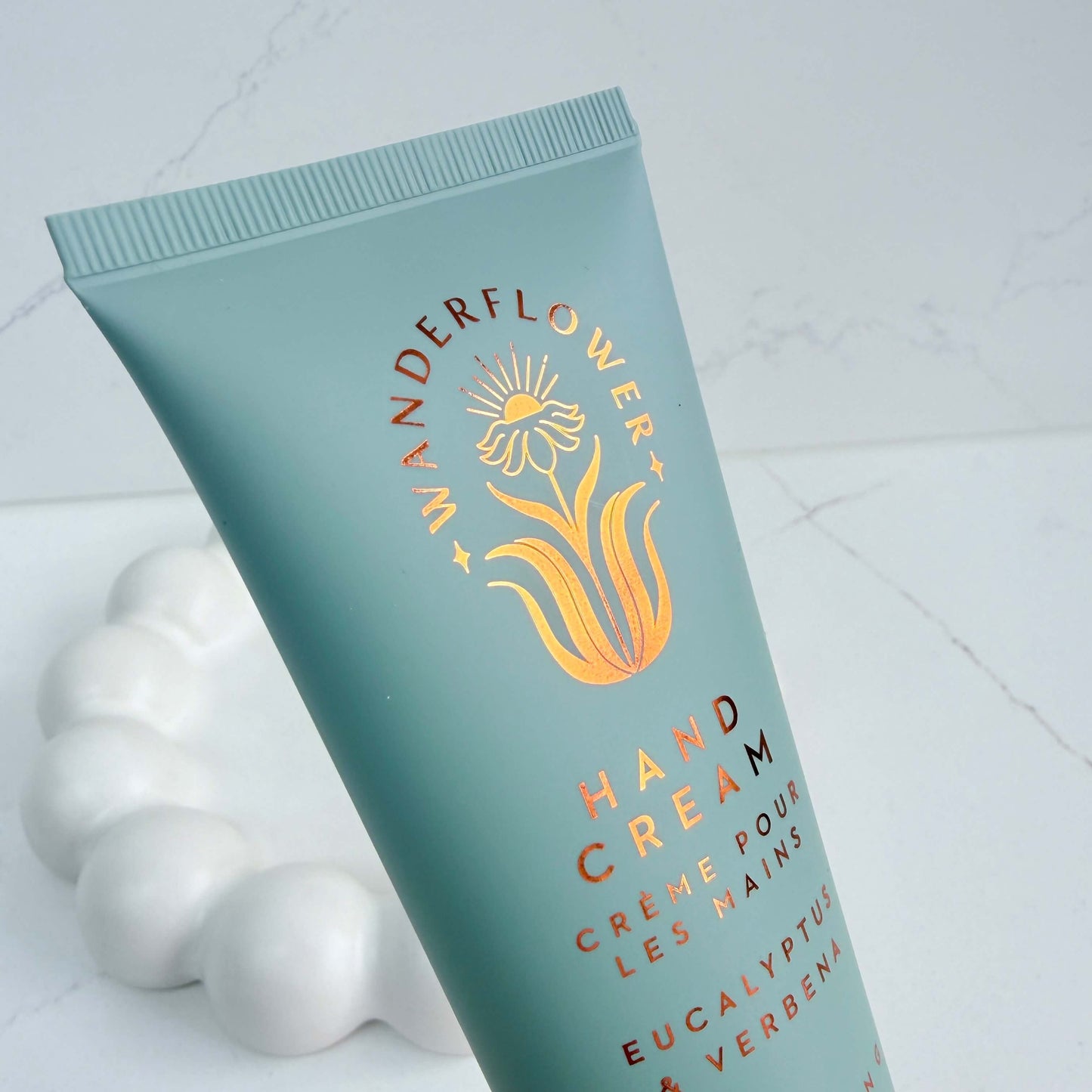 Close-up of eucalyptus and verbena hand cream tube by Wanderflower