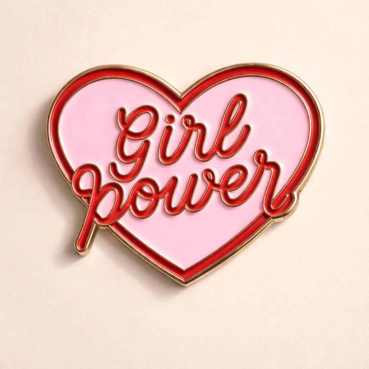 Close up of Girl Power heart enamel pin badge in pink enamel with gold and red detailing