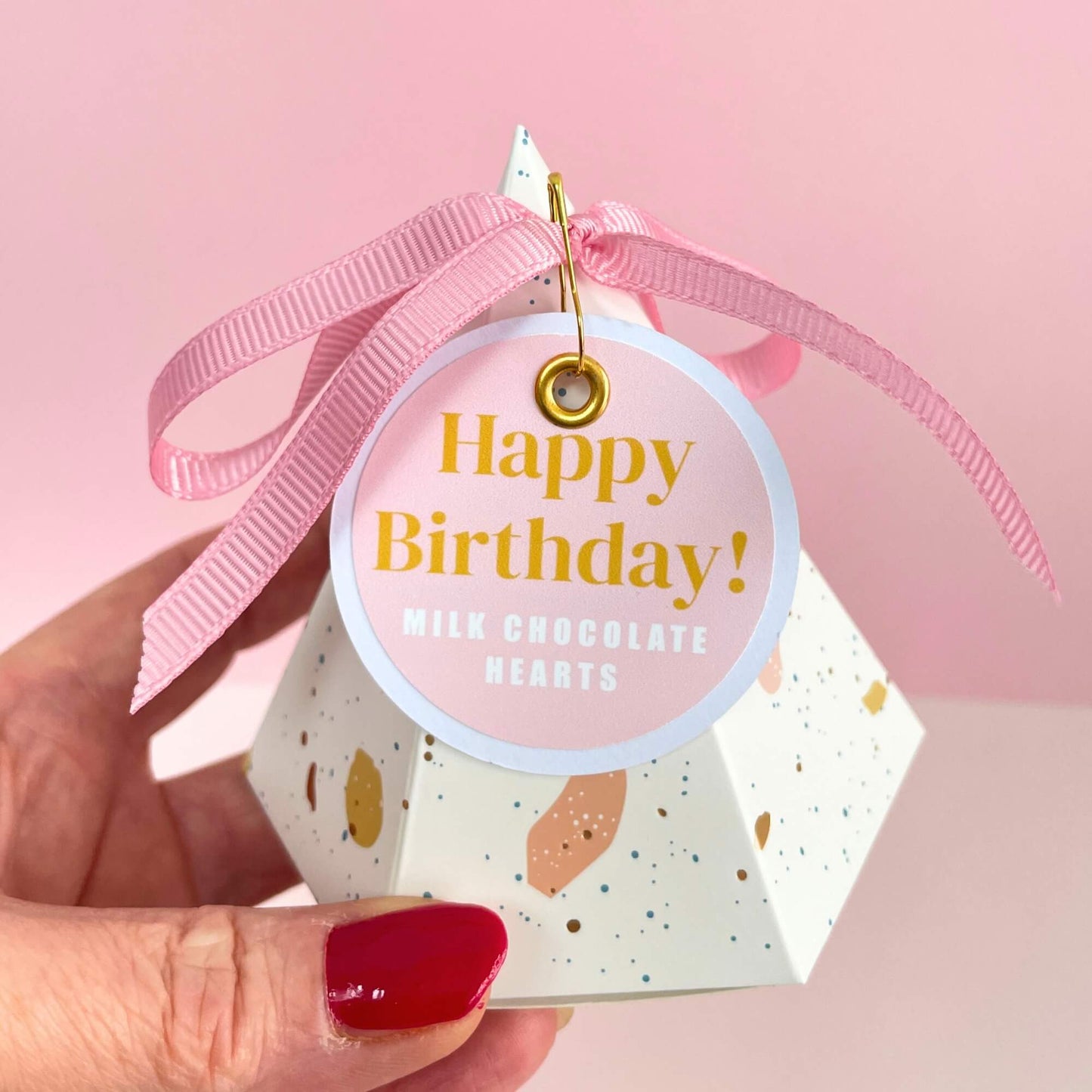 Hand holding a happy birthday pyramid gift box