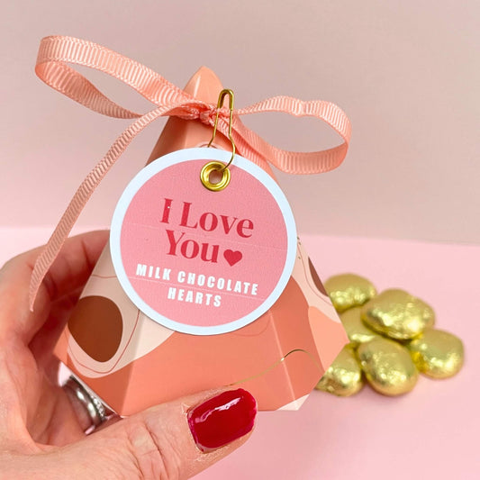 hand holding a pyramid shaped gift box with an I Love You gift tag and milk chocolate hearts