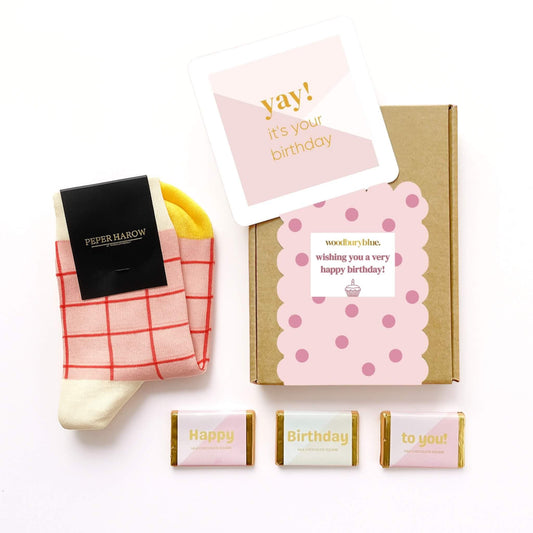 Happy Birthday Socks and Chocolates Letterbox Gift with pink and yellow grid socks, birthday card and three chocolate squares by Woodbury Blue.