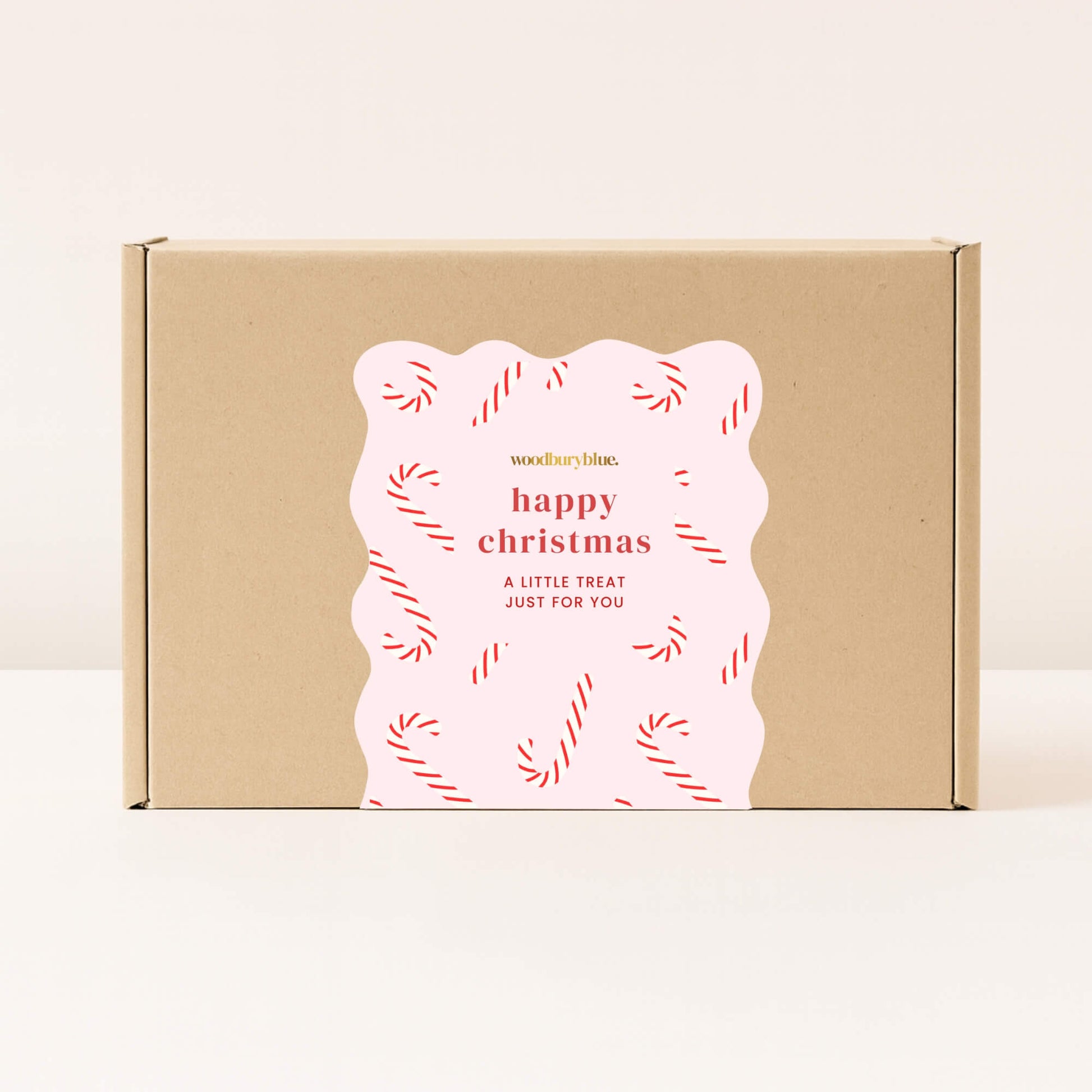 Kraft gift box with pink happy Christmas sticker decorated with red candy canes from Woodbury Blue