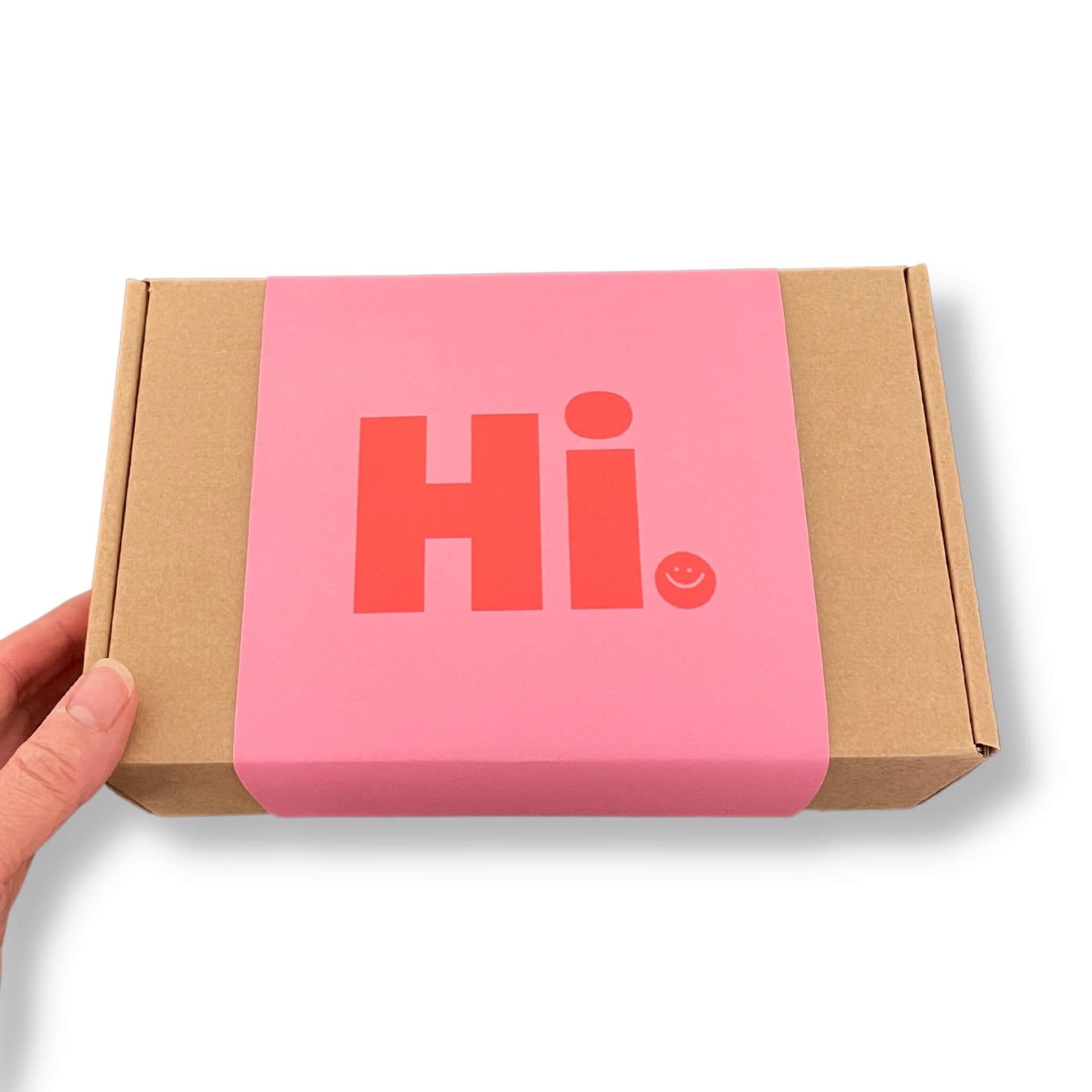 Kraft gift box with a pink sleeve and red 'Hi' and smiley face on the front