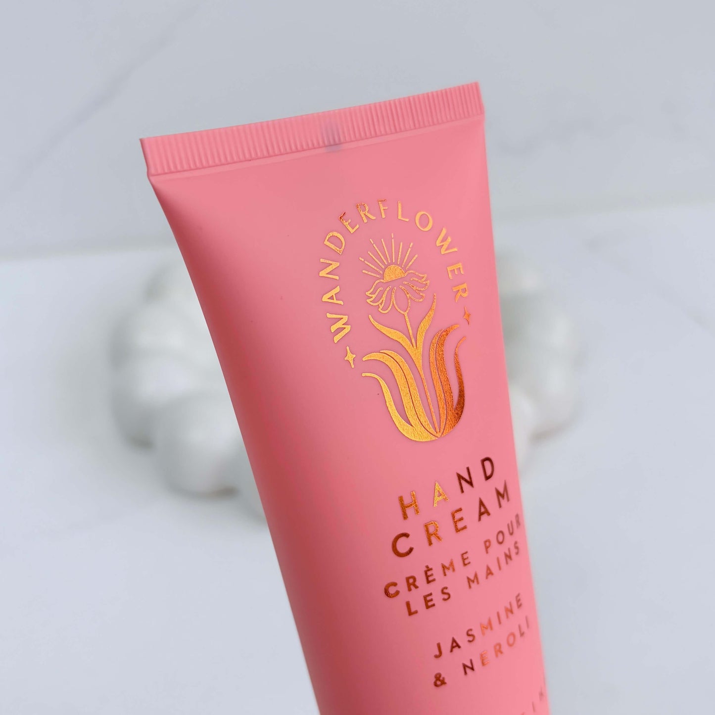 Close-up of jasmine and neroli hand cream tube by Wanderflower