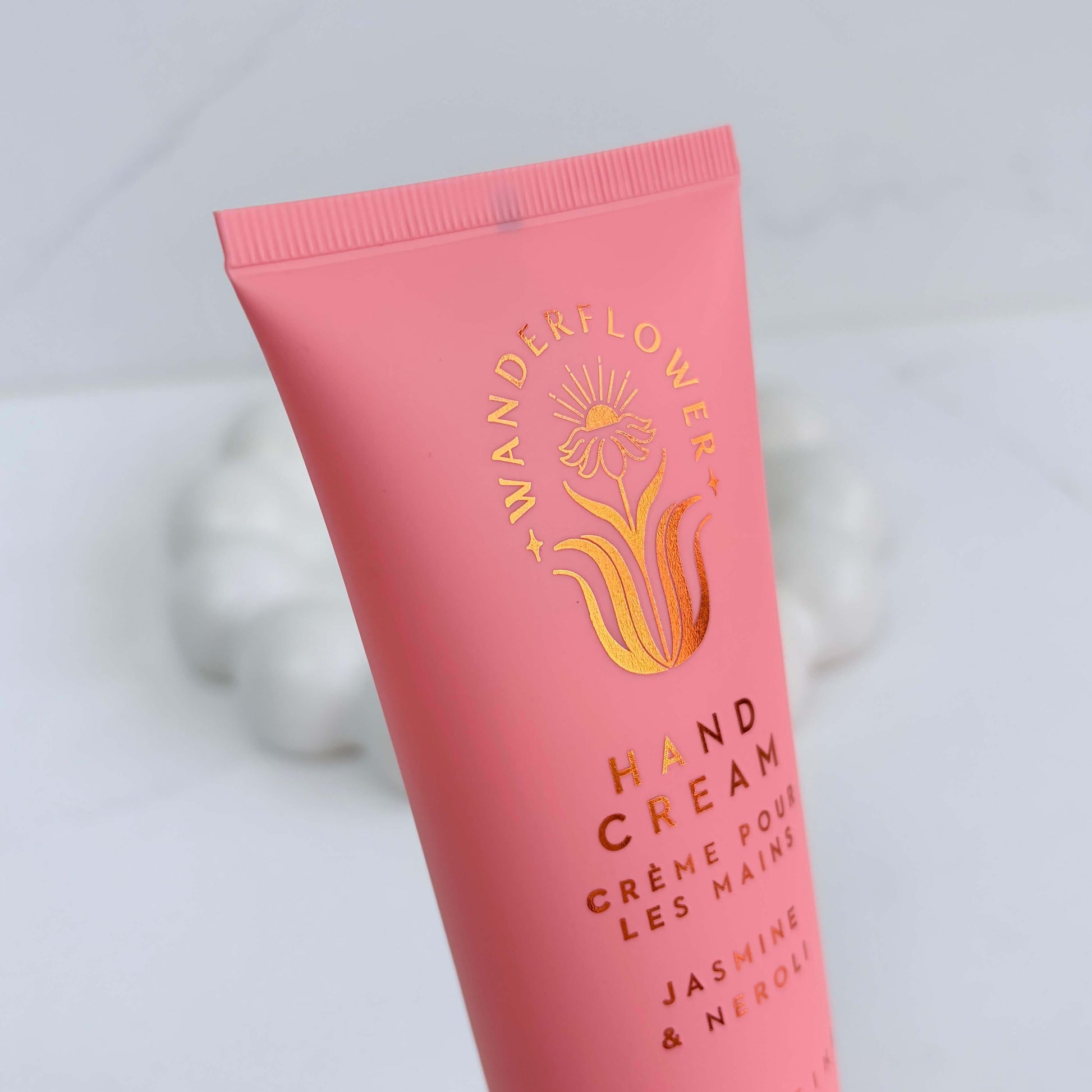 Close-up of jasmine and neroli hand cream tube by Wanderflower