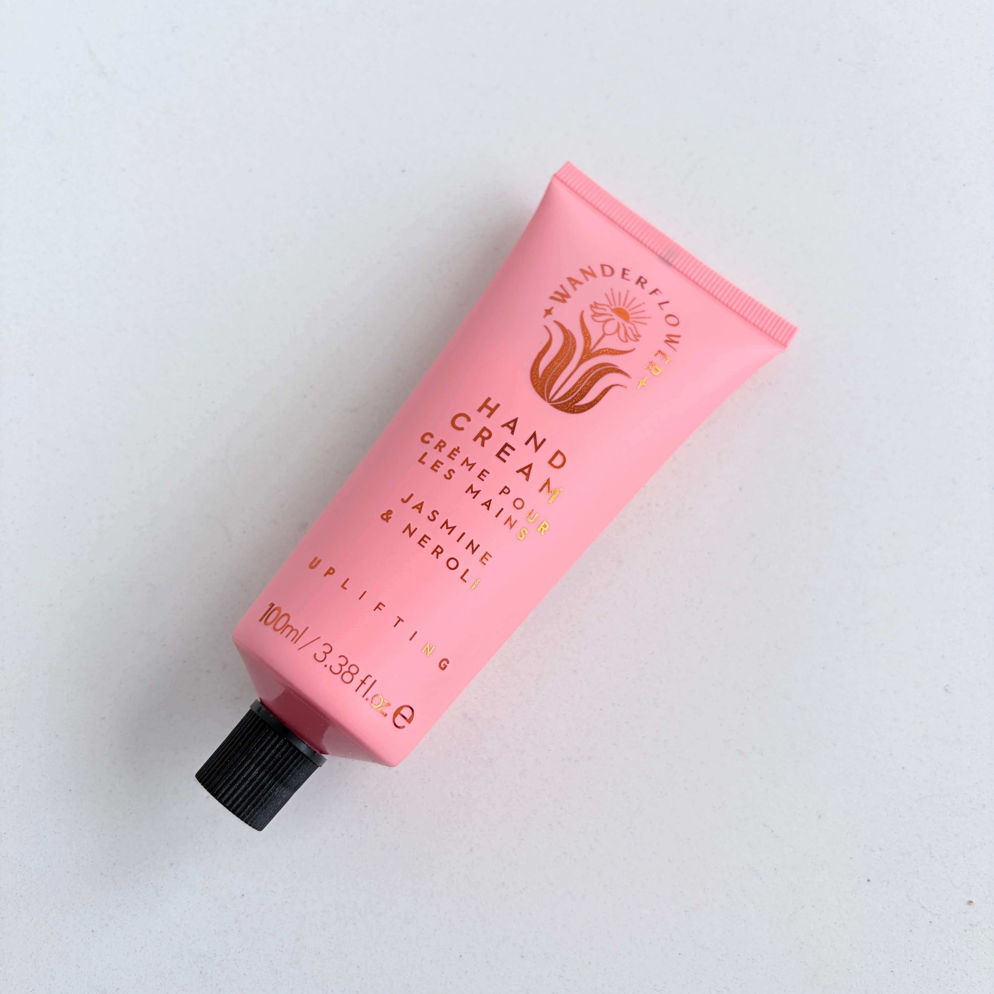 Jasmine and neroli hand cream tube laid flat on a light background