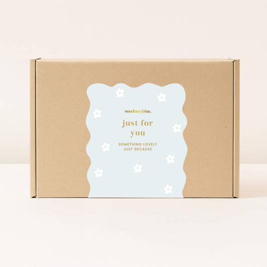 Kraft gift box with pale blue just for you sticker decorated with simple white daisy flowers from Woodbury Blue