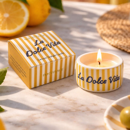 Lit La Dolce Vita ceramic tealight candle with yellow and white stripes beside its matching gift box