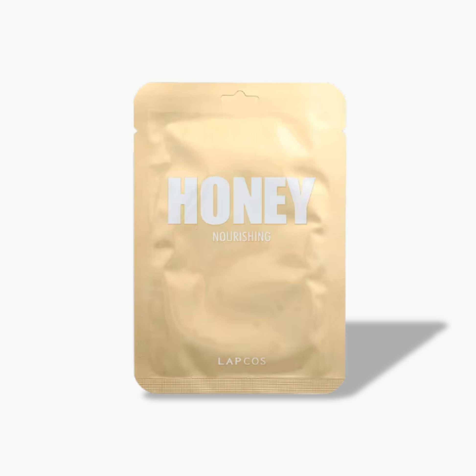 LAPCOS Honey Nourishing sheet mask in gold metallic pouch with shadow on light background