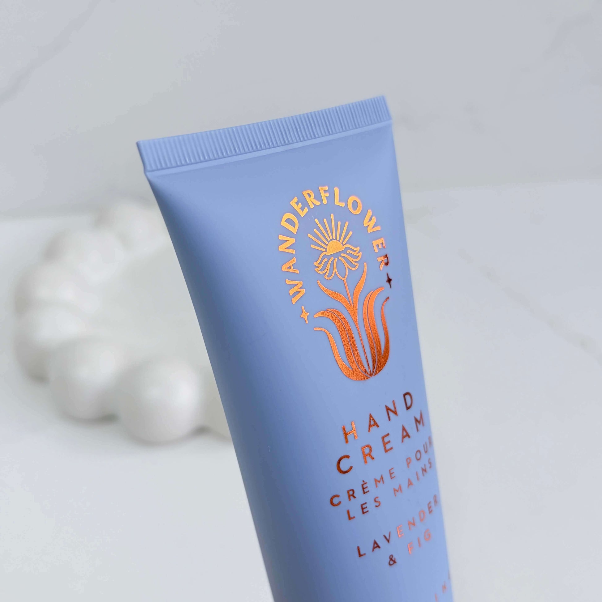 Close-up of lavender and fig hand cream tube by Wanderflower