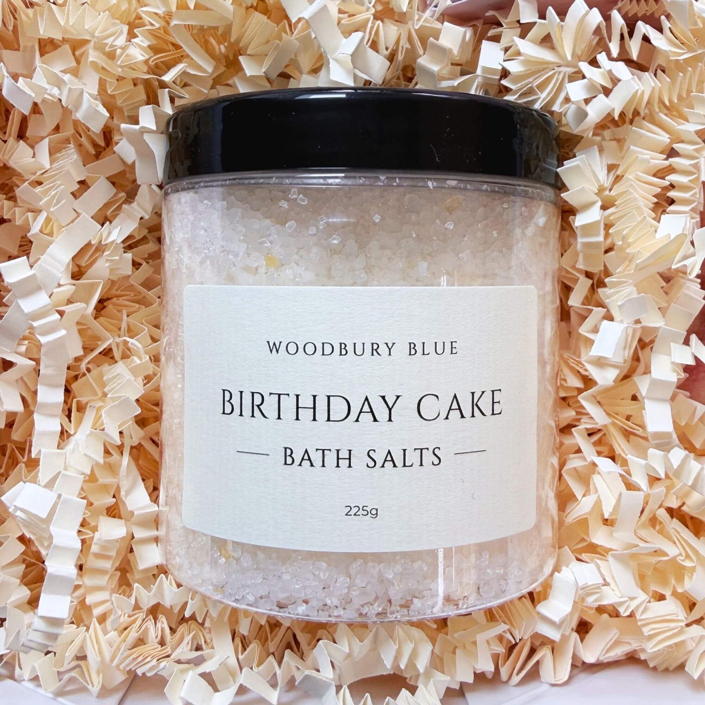 Birthday cake bath salts inside a luxury birthday gift box with cream shredded paper.